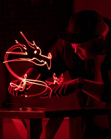 积家 - 名家造艺，王思博正在一枚Reverso翻转系列腕表上方光绘一只红色飞龙